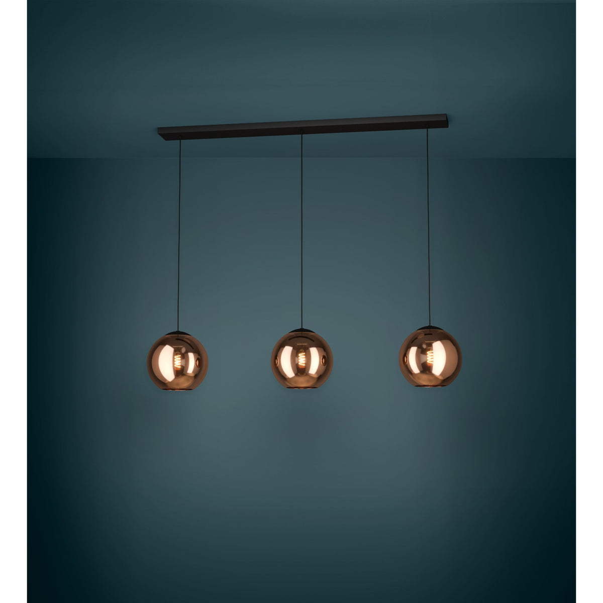Trelbette 3-light linear pendant with black steel bar and cords suspending three copper-toned mirrored glass globe shades, lit against a dark teal background.