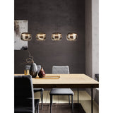 Hortunas Smoked Glass Linear Pendant Light in black, four rounded smoked glass shades on black cords suspended over a wooden dining table, LED warm-white glow.