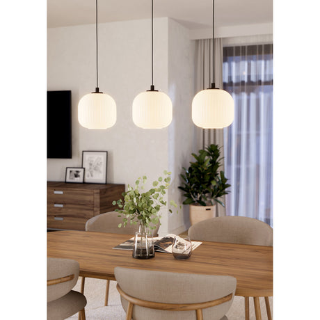 Trolmane three-light linear pendant with black cords and ribbed white glass lantern shades, shown hanging over a wooden dining table in a living space.