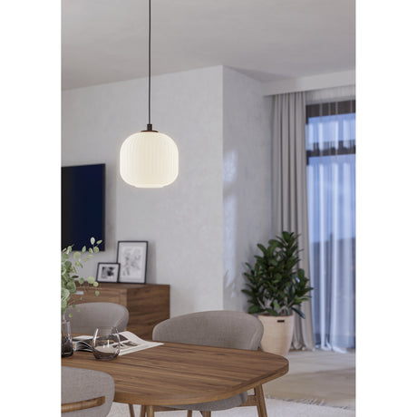 Trolmane Glass Pendant Light with ribbed white globe shade and black cord and canopy, hanging above a wooden dining table in a living room setting.