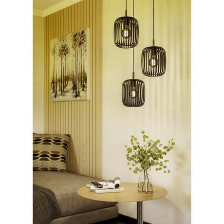 Trosvelle 3 Light Pendant in black steel with slatted barrel-shaped cage shades at staggered heights, shown above a side table in a living room setting.