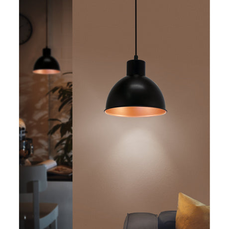 Truro 1 pendant light with a round black dome shade and copper-coloured interior, hung on a black cord above a warm-toned living room wall.
