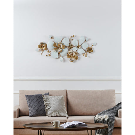 Tupiza Wall Decoration in white and gold, a metal flower wall art piece with large ribbed white petals and gold centres, displayed above a beige sofa.