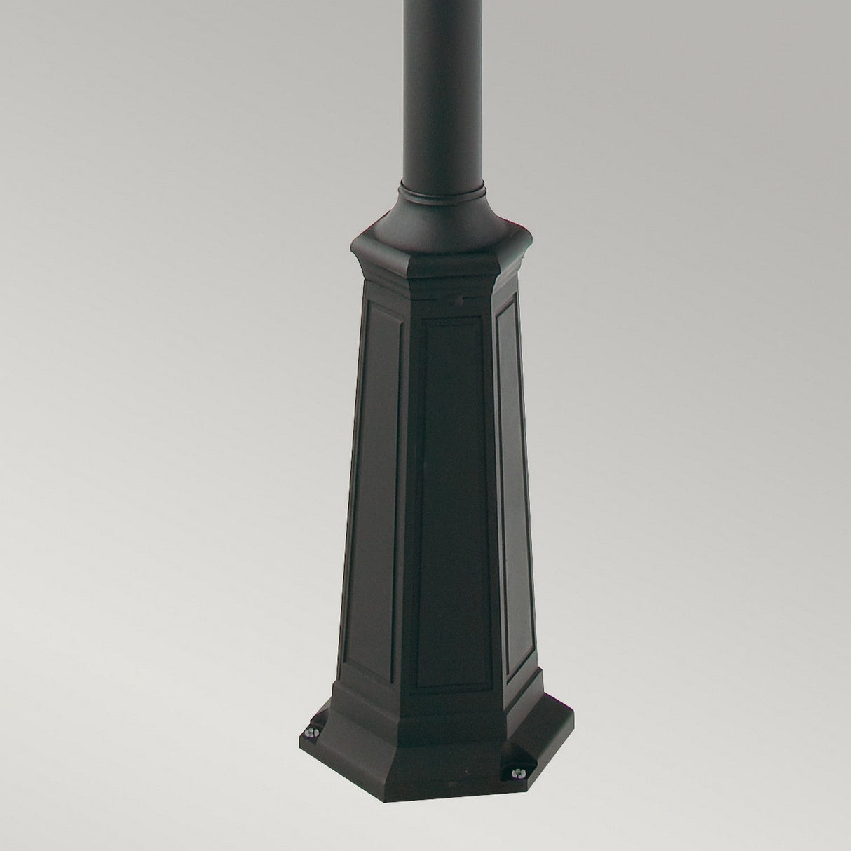 A tall, black lamp post base featuring a square design and intricate detailing, reminiscent of the sophisticated Valencia 3 Light Triple Head Lamp Post - Black style, is set against a neutral gray background.