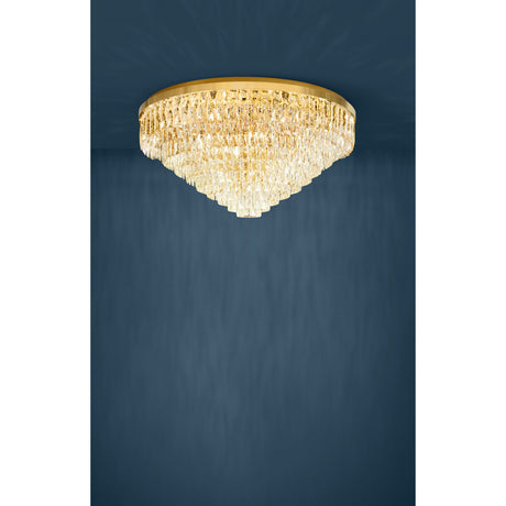Valparaiso 25 Light Ceiling Light in gold, a round flush fitting with a steel ring and tiered clear faceted glass drops tapering to a point, shown against a dark blue background.