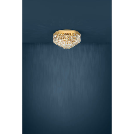 Valparaiso 8 Light Ceiling Light in Gold, a round flush fixture with tiered faceted crystal glass drops and a gold steel body, shown against a dark blue background.