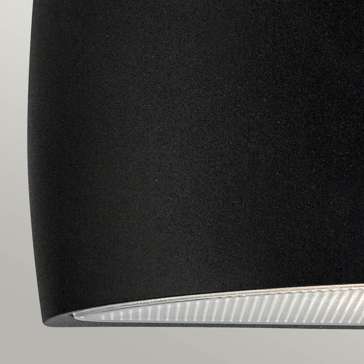 Close-up of the Vasa Outdoor 1 Light Wall Light in a sleek graphite finish, crafted from die-cast aluminum and showcasing its smooth cylindrical shape with a partial view of the light diffuser at the bottom. Perfectly suited as an outdoor wall light with an IP65 rating, it stands out against a neutral gray background.