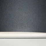 Close-up of the Vasa Outdoor 1 Light Wall Light in Graphite, featuring a textured black finish with a white interior edge, crafted from die-cast aluminum, set against a light gray background.