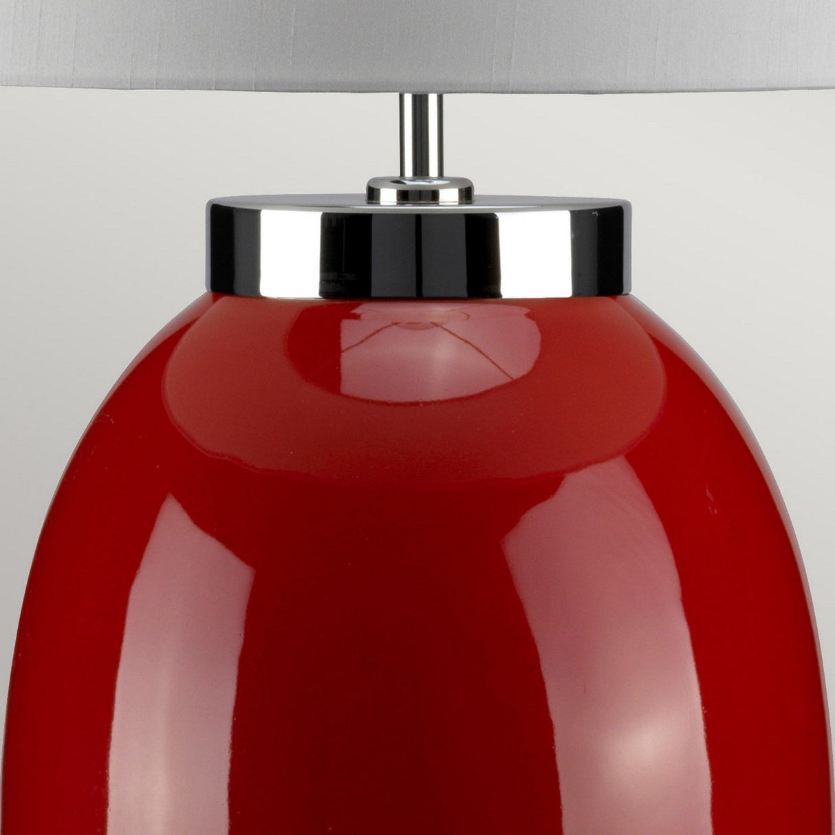 The Victor 1 Light Large Table Lamp in a vibrant red color features a smooth, glossy ceramic finish with a sleek metallic black and chrome base, radiating modern elegance. It is crowned with a light gray lampshade, making it an eye-catching piece against the plain white background and embodying sophisticated lighting.