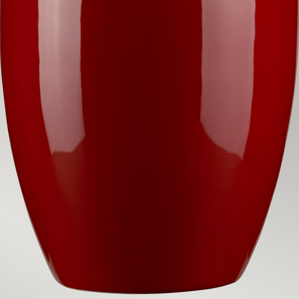 Close-up of the Victor 1 Light Large Table Lamp in a vibrant red hue, set against a neutral background. The lamp features a smooth, glossy finish with a slightly tapered shape that resembles an elegant ceramic vase. Light reflections dance gracefully on its surface.