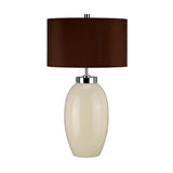 Introducing the Victor 1 Light Small Table Lamp in Cream, showcasing a glossy white ceramic base with an elegant oval shape. It's topped with a sleek dark brown faux silk cylindrical lampshade, all seamlessly connected by a modern metal accent.