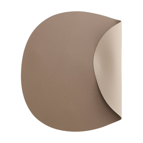 Vinanivao reversible pebble-shaped placemat in brown and beige, fine-grain textured plastic with a curled corner, shown on a white background.