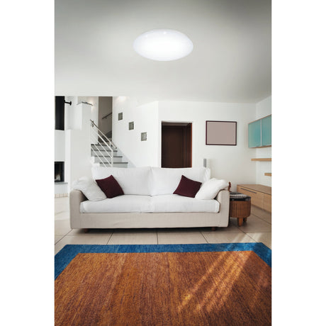 Vinvanne round white LED flush ceiling light with crystal-effect diffuser, shown installed on a living room ceiling above a white sofa and rug.
