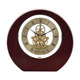 Round mantel clock in mahogany piano gloss wood with gold-tone dial, black Roman numerals, visible skeleton gears, and black hands, set against a plain white background.