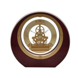 Round mantel clock with mahogany piano gloss wood case and open gold-tone skeleton movement visible through the centre, gear hands, on a plain white background.