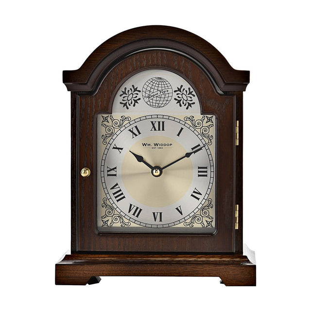 Broken arch wooden mantel clock in walnut finish with silver Roman numeral dial, gold centre, scroll motifs, globe and "Tempus Fugit" text, on a white background.
