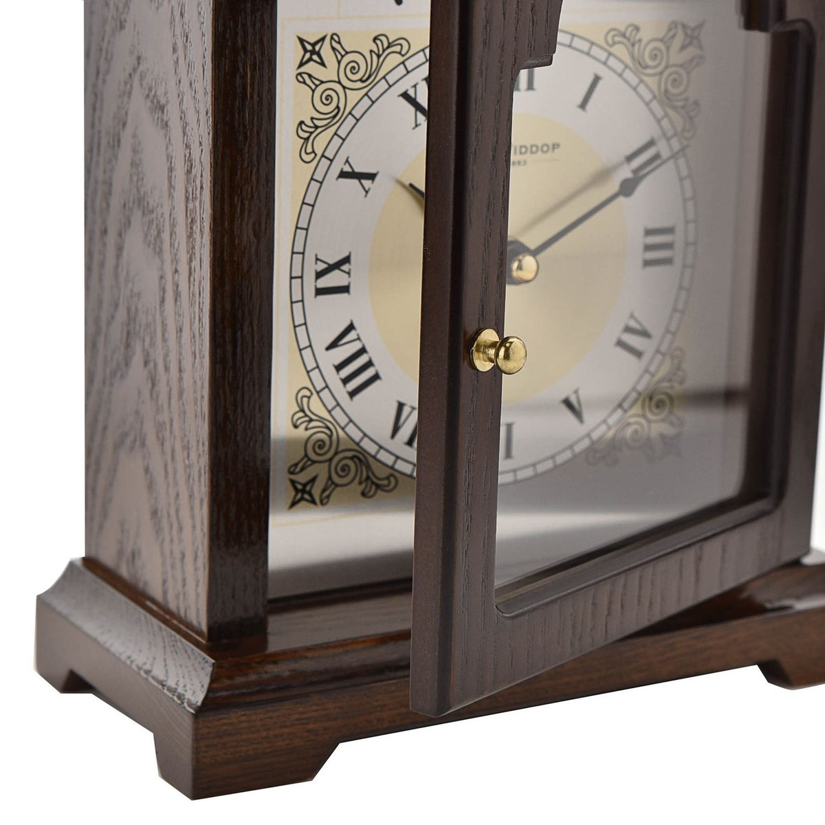 Close-up of the Broken Arch Roman Dial Wooden Mantel Clock in walnut, showing the glazed door, brass knob, Roman numeral dial, and scrolled corner detailing.