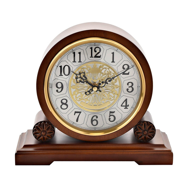 Westminster Barrel Mantel Clock in walnut finish with round gold bezel, silver-white Arabic numeral dial, ornate gold filigree centre, and carved wooden base, on a plain white background.