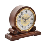Walnut-finish Westminster Barrel Mantel Clock with round silver-white dial, black Arabic numerals, gold bezel, filigree centre, scrolled hands, and plinth base with carved finials.