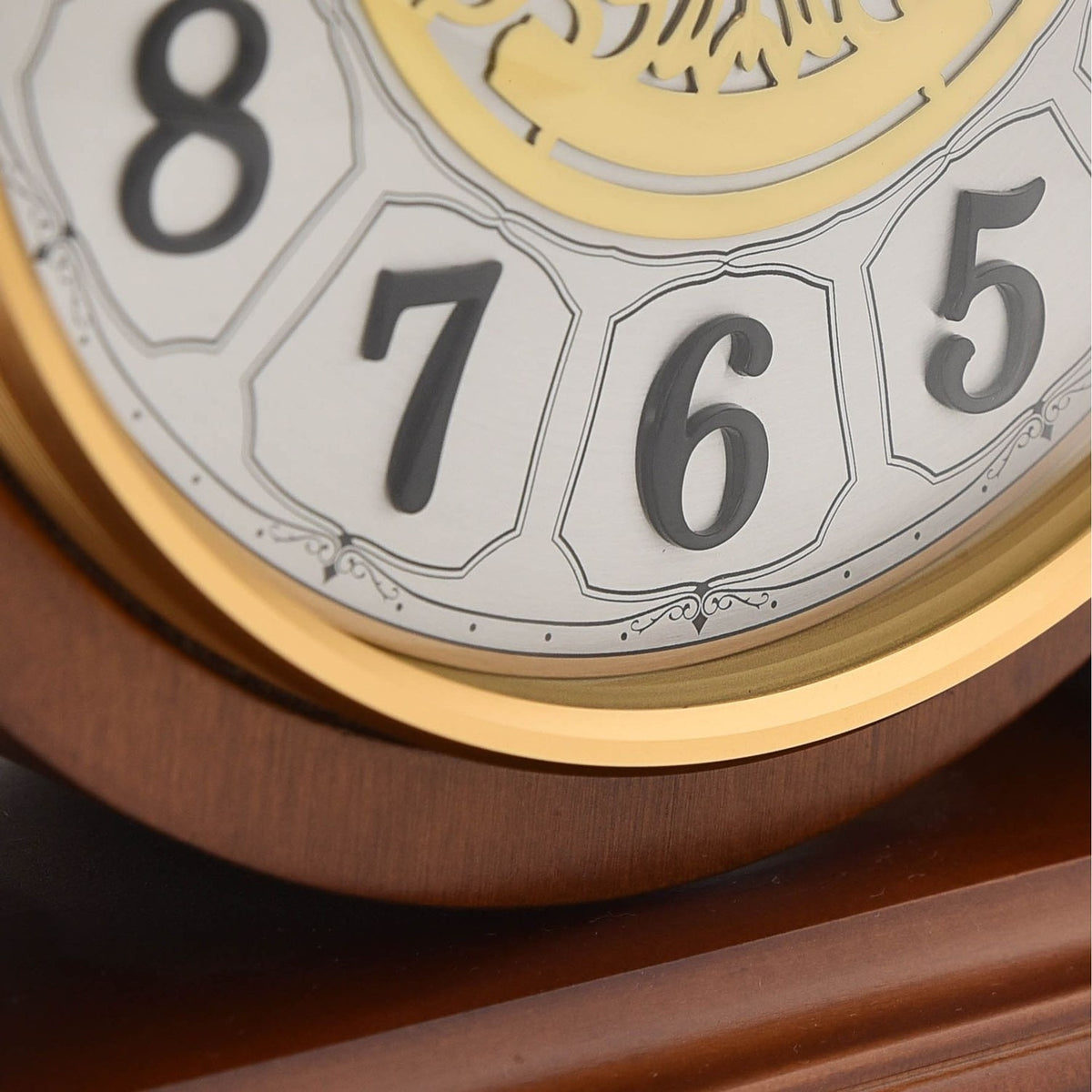 Close-up of the Westminster Barrel Mantel Clock in walnut, showing black Arabic numerals 5, 6, 7 and 8 in outlined panels with a gold-coloured bezel and filigree centre detail.