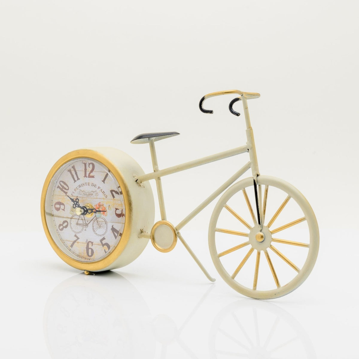 Vintage bicycle mantel clock in distressed cream with gold-accented spokes, chainring, and dial rim, featuring a round quartz clock face as the rear wheel, on a white background.