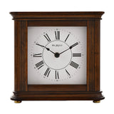 Square Westminster chime mantel clock in walnut effect case with fluted side columns, white dial, black Roman numerals, and spade hands, on a plain white background.