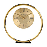 Round gold metal mantel clock with a slim outer ring and a two-tone dial featuring black Roman numerals and baton markers, set on a small black base against a white background.