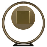 Round metal mantel clock in a gold finish, featuring a slim open ring frame with a solid gold dial centred inside, set on a black base against a plain white background.