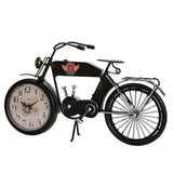 Motorcycle Metal Mantel Clock in matt black with front-wheel clock face, Arabic numerals, CUSTOM MOTORS fuel tank badge, handlebars and spoked wheels, on a plain white background.