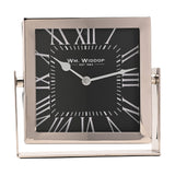 Square silver-framed mantel clock with black dial, white Roman numerals, and silver hands, mounted on a matching silver stand against a plain white background.