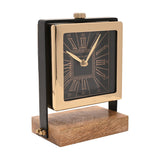 Square mantel clock with black Roman numeral dial in a polished gold case, flanked by black uprights on a rectangular wooden base, shown on a white background.