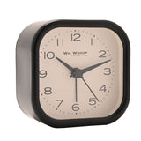 Rounded square metal alarm clock in black with a cream dial, bold Arabic numerals, and slender black hands, shown on a plain white background.
