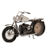 Motorbike-shaped metal mantel clock in black and silver, with a round cream clock face set into the rear wheel, spoked silver front wheel, and kickstand, shown on a plain white background.