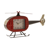Helicopter mantel clock in metal with a rounded red cabin clock face, black tail boom and tail rotor, top rotor blades, and black landing skids, shown on a white background.