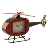 Helicopter Metal Mantel Clock with red rounded cabin, black tail boom and rotor, top rotor blades, cream dial with black numerals, and black landing skids, on a plain white background.
