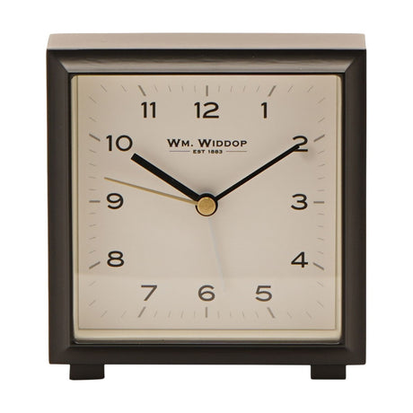 Square metal alarm clock with black bevelled case and cream dial, bold black numerals, black hands with gold centre, standing on small feet against a white background.