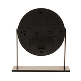 Rear view of the Round Adjustable Metal Alarm Clock 13.5cm in black, showing control switches, alarm and time-set dials, and battery compartment on a black metal stand.