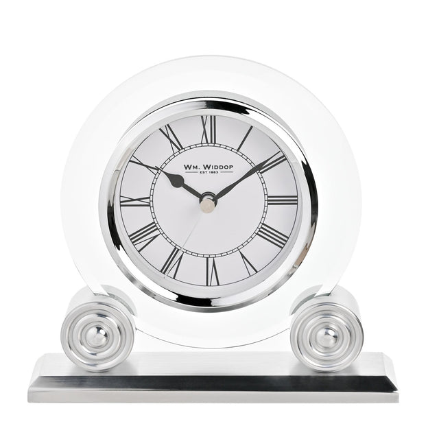Round glass mantel clock with a white Roman numeral dial and silver bezel, set in a clear glass disc on two round silver supports with a flat base, shown on a plain white background.