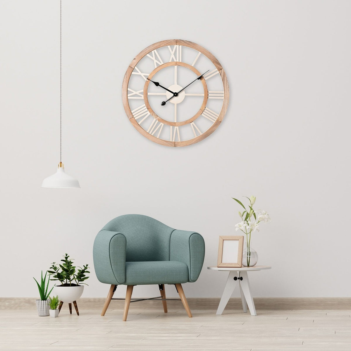 Shabby Chic round MDF wall clock, 60cm, with cut-out Roman numeral dial in white and wood-tone finish, shown above a sage armchair in a living room setting.