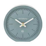 Round matt teal mantel clock, 15.4cm, with a numeral-free dial, baton hour markers, white hands and gold centre detail, set against a plain white background.