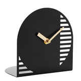 Black steel arched mantel clock with gold hands, cut-out slot stripes along one curved edge, a triangular accent in the opposite corner, and a numberless face.