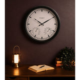 Round 45cm wall clock with black frame and white dial, featuring black baton markers, two hands, and small temperature and humidity gauges, displayed above a desk.