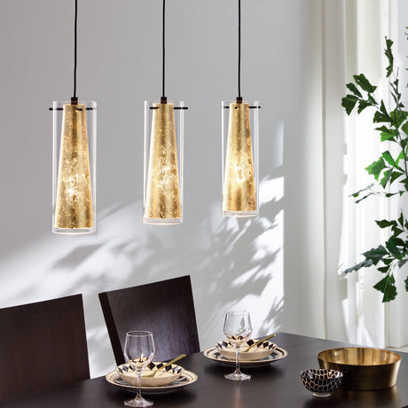 Wasmelle 3-light linear pendant light in black with clear glass cylinders and gold cone inserts, hung over a dining table with black chairs and tableware.