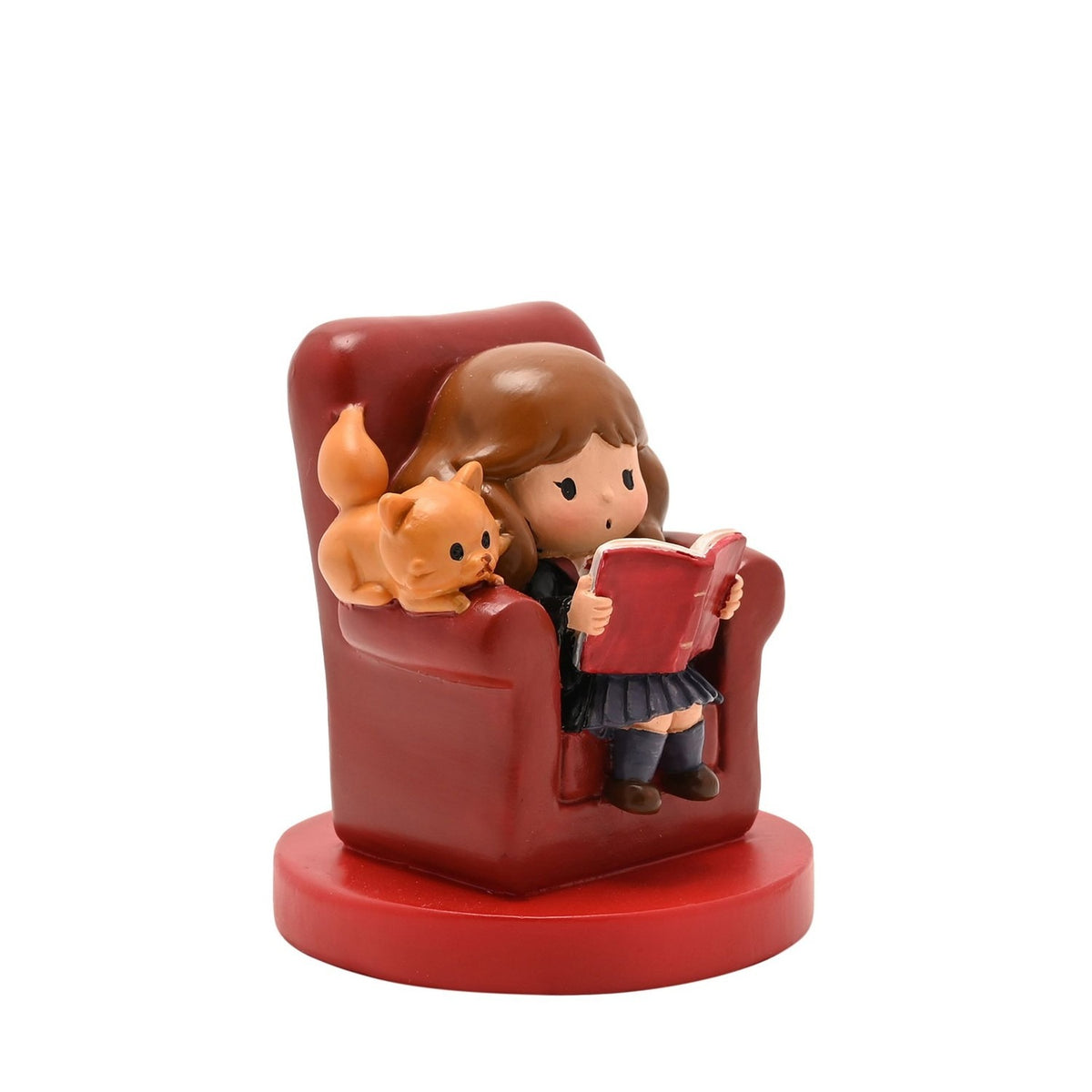 Harry Potter Hermione and Crookshanks resin figurine, seated reading in a red armchair with her ginger cat beside her, on a round red base against a plain white background.