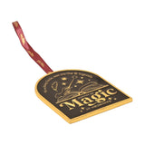 Arched black and gold metal wall decoration featuring "History of Magic at Hogwarts" design with wand, book, quill and stars, hung on a maroon ribbon against a white background.
