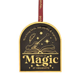 Arched black and gold metal decoration featuring Harry Potter's "History of Magic at Hogwarts" design with a wand over an open book, quill, and stars, on a burgundy ribbon against a white background.