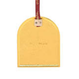 Reverse side of the Harry Potter History of Magic arched metal decoration, showing a plain gold-toned back with maker's mark and burgundy ribbon loop, on a white background.