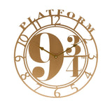 Gold cut-out round wall clock featuring "PLATFORM" arched across the top and a bold 9¾ dial, with open numeral ring and slim gold hands, shown on a plain white background.