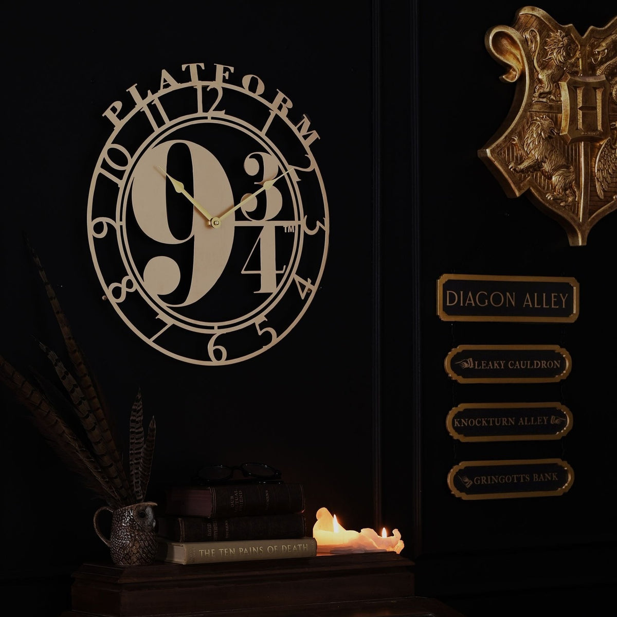 Harry Potter Platform 9¾ round wall clock in metallic gold, open cut-out design with arched "PLATFORM" text and bold 9¾ dial, displayed on a dark wall.