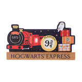 Wooden mantel plaque shaped like the Hogwarts Express red engine 5972 with Platform 9¾ sign, a snowy owl atop luggage, resting on a gold "Hogwarts Express" base, shown on a white background.